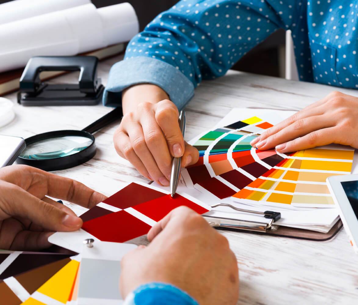 Close Up of Hands Using Pantone Swatch System to Pick Out Color Scheme