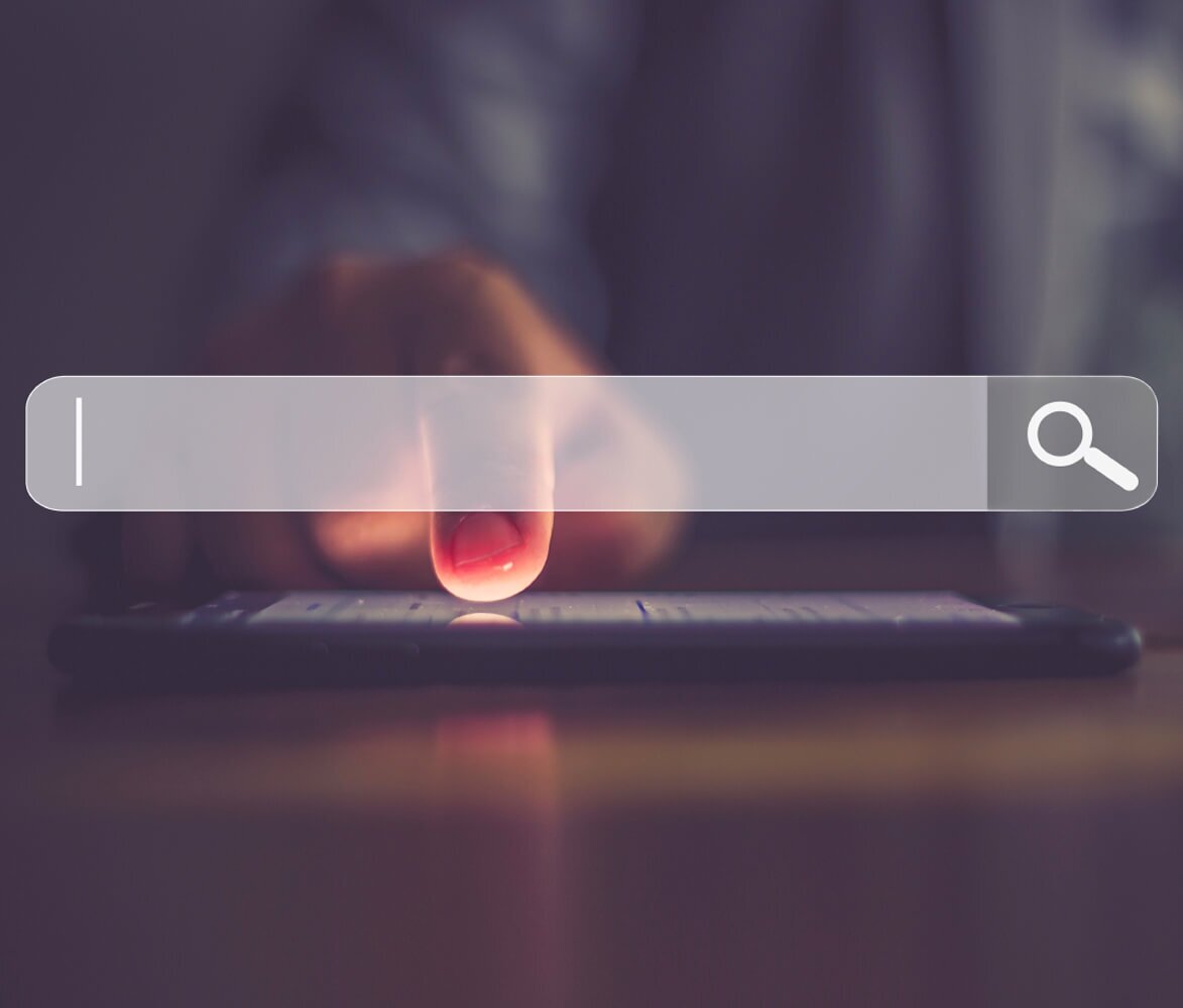 Close Up of Person's Hand on Cell Phone Screen, Website Search Bar Graphic Over Top