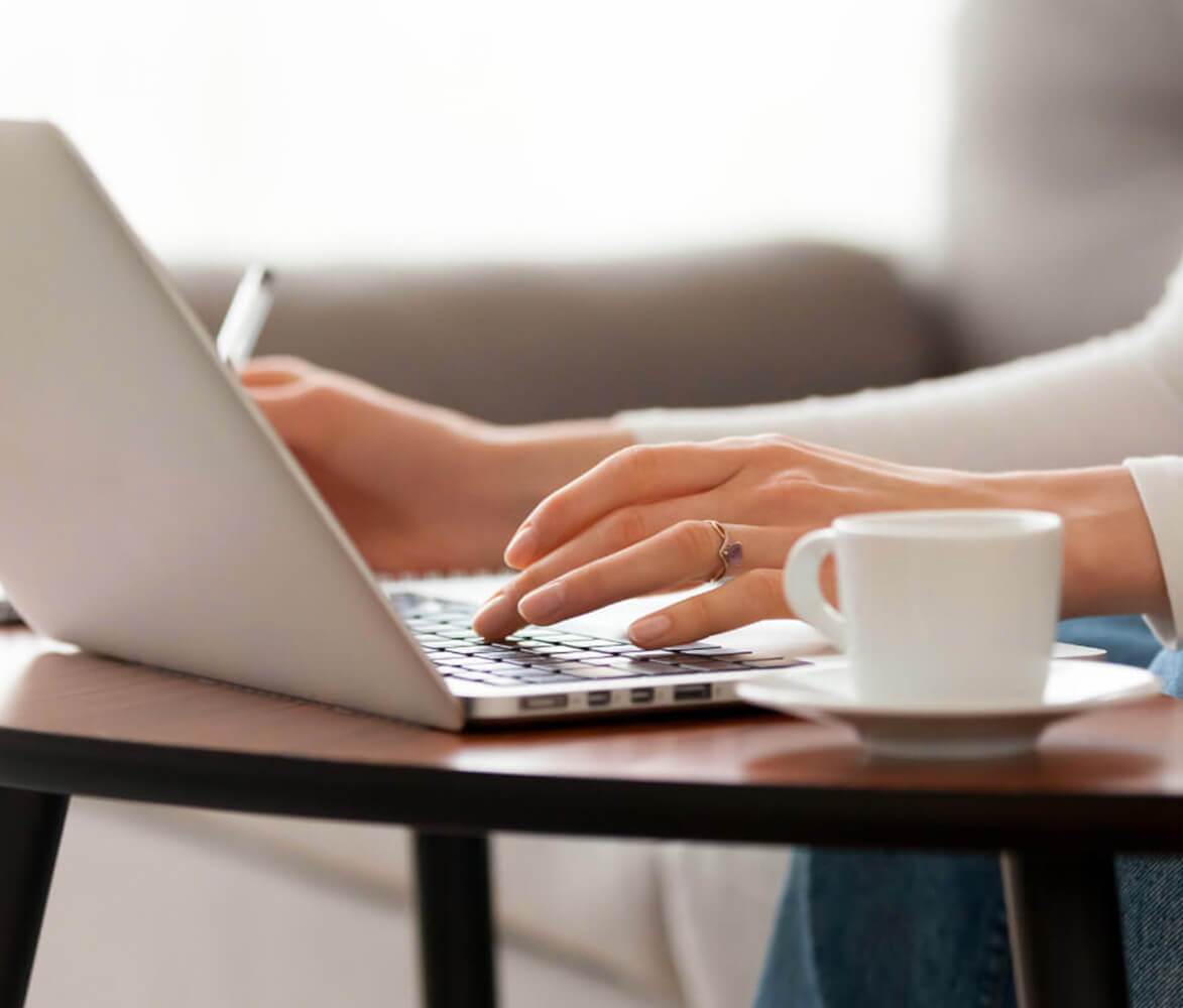 Close up of Hands On Laptop Keyboard in Modern Living Room