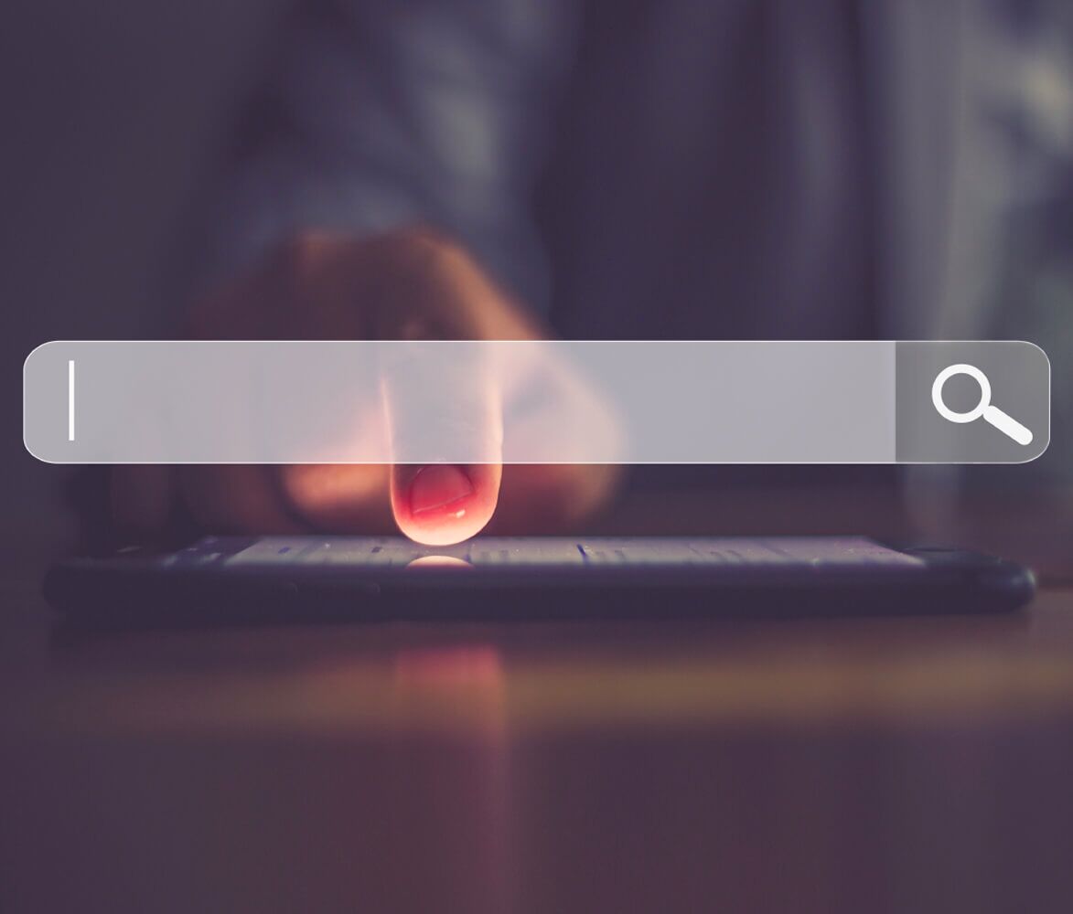 Close Up of Person's Hand on Cell Phone Screen, Website Search Bar Graphic Over Top
